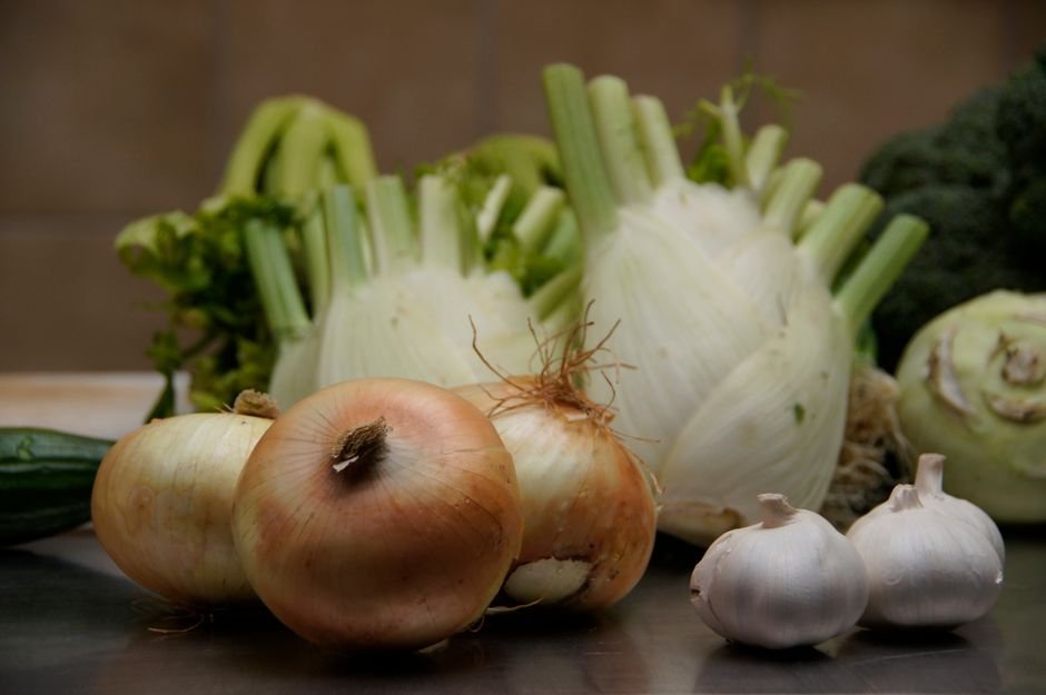 Ingredientes frescos de temporada organizados sobre mesa de madeira