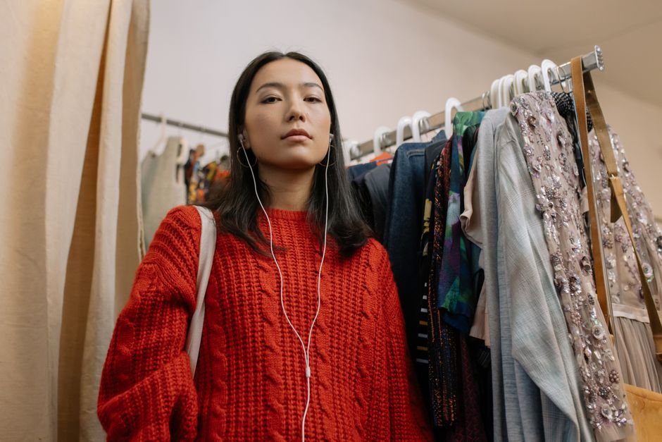 Vendedora auxiliando cliente na escolha de roupas na loja